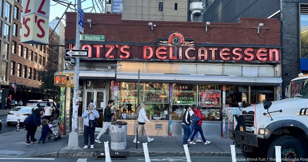 The exterior of Katz's Delicatessen in NYC with people walking past